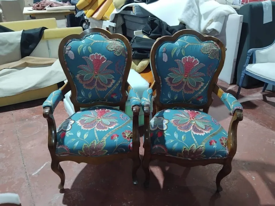 Sofá de tres plazas con brazos de madera, tapizado en tela amarilla, en el taller