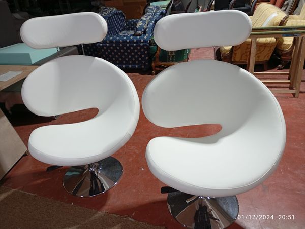 Dos sillones giratorios de diseño tapizados en blanco